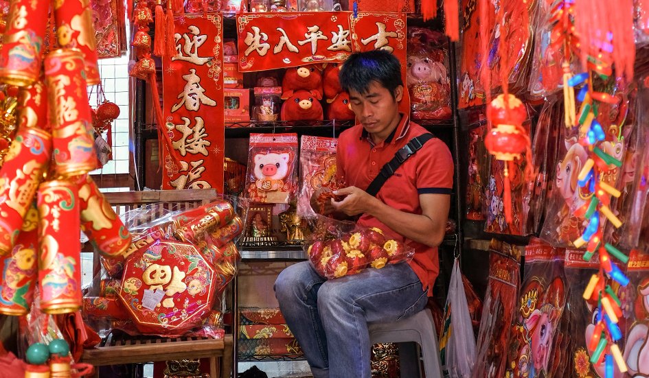 A man sits on a stool in an award-winning Chinese market. A man sits on a stool in an award-winning Chinese market.