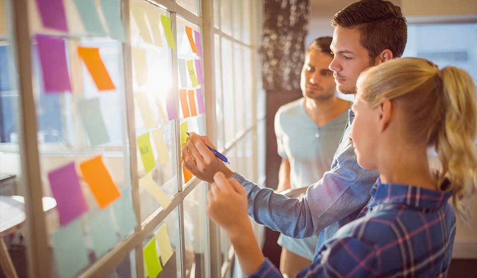 A award winning group of people in front of a window with sticky notes. A award winning group of people in front of a window with sticky notes.