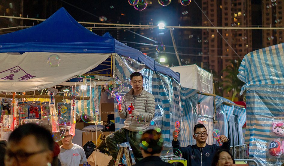 A group of people in Hong Kong standing in front of a tent with soap bubbles. A group of people in Hong Kong standing in front of a tent with soap bubbles.