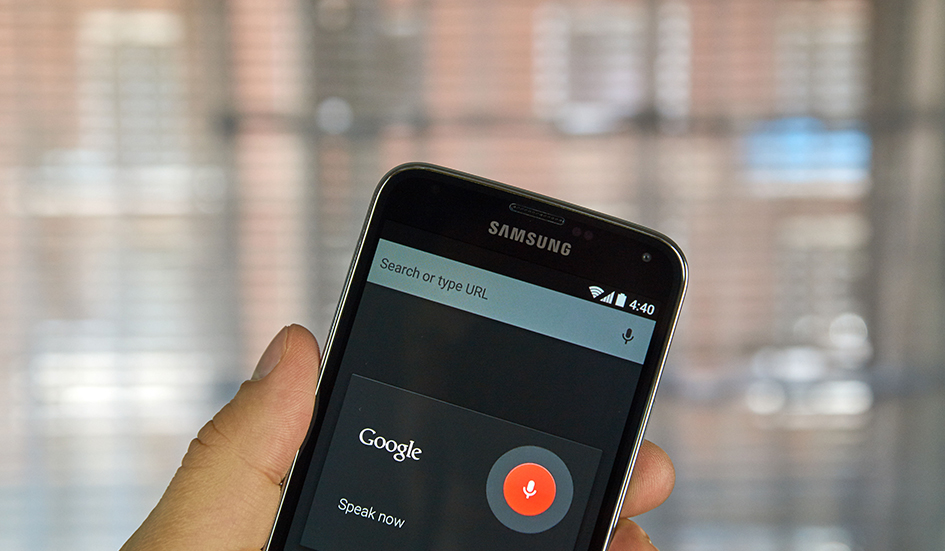 A person in Hong Kong is holding up a Samsung phone with Google voice on it. A person in Hong Kong is holding up a Samsung phone with Google voice on it.