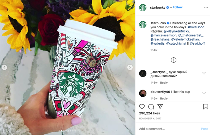 A person in Hong Kong is holding up an award-winning Starbucks cup with a flower on it. A person in Hong Kong is holding up an award-winning Starbucks cup with a flower on it.